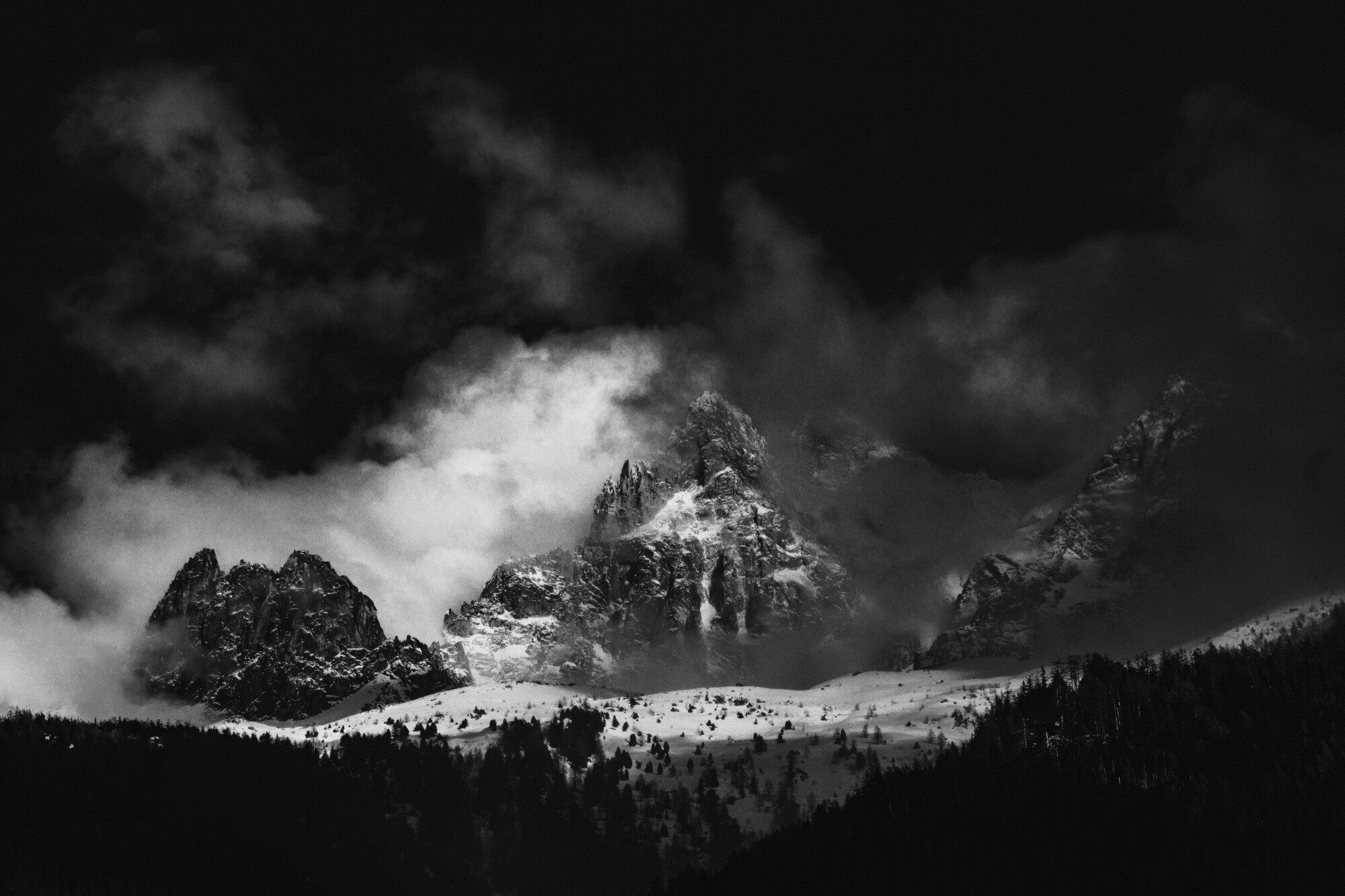 A ski tourer with skis on the pack looks across an untouched snowfield.